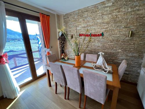 een eetkamer met een tafel en stoelen en een bakstenen muur bij Villa Dream Arachova in Arachova
