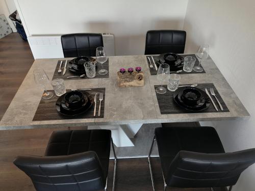 - une table à manger avec des chaises, des assiettes et des verres à vin dans l'établissement Seaview, à Middelkerke