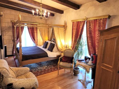 - une chambre avec un lit à baldaquin et une chaise dans l'établissement Rezidence Zámeček - Boutique Hotel, à Františkovy Lázně