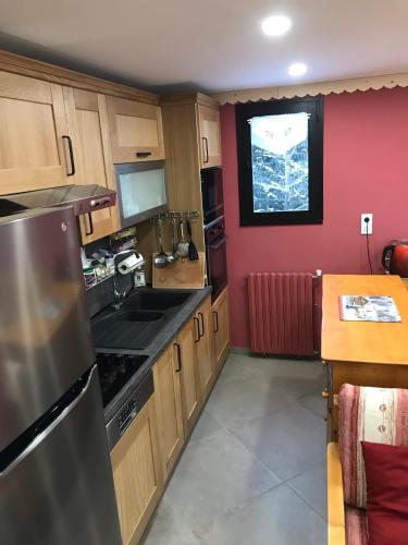 une cuisine avec des armoires en bois, un évier et une fenêtre dans l'établissement Grand Sud, à Courchevel