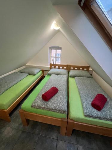 a room with two beds with red pillows on them at Dům Pod Věží in Mikulov