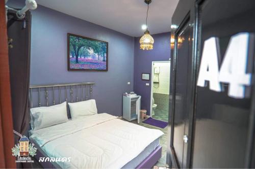 a bedroom with a white bed and a purple wall at ลิลล์ลดา บูติค โฮเต็ล in Ban Na Oi