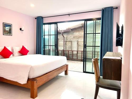 1 dormitorio con cama y ventana grande en Baan Purada, en Ko Lanta