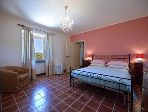 - une chambre avec un lit, une chaise et un lustre dans l'établissement Villa Santa Maria Deruta, à Deruta