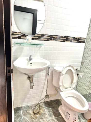 a bathroom with a sink and a toilet and a mirror at Baan Purada in Ko Lanta