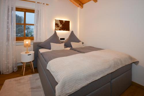 ein Schlafzimmer mit einem großen Bett vor einem Fenster in der Unterkunft Bodenmaiser Herz-Hoamad Ferienwohnung Bierl in Bodenmais