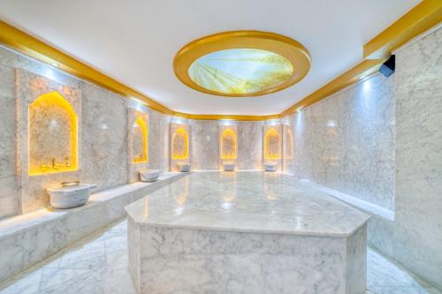 a large marble room with a round mirror on the ceiling at Aria Riva Apart Hotel in Alanya