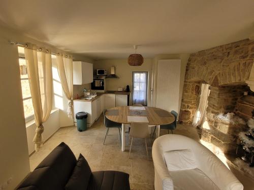 uma sala de estar com uma mesa e uma cozinha em Maisonette em Muret-le-Château