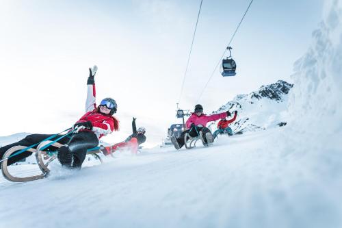 two people on a ski lift in the snow at Quality Hosts Arlberg - AFOCH FEI - das Landhaus in Sankt Anton am Arlberg