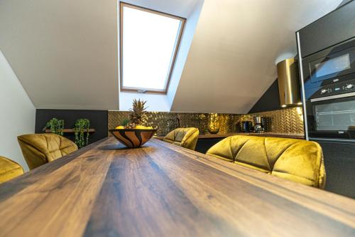 a dining room with a wooden table and yellow chairs at Apartament w Cieplicach Panorama in Jelenia Góra