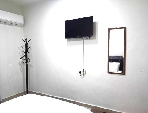 a white room with a tv and a mirror at iG Hotel in Alor Setar