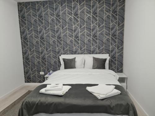 a bedroom with a large bed with two towels on it at Global Residence Lake View in Bucharest