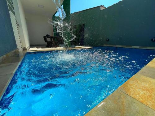 a swimming pool with a splash of water at Hotel Cajueiro Guarujá in Guarujá