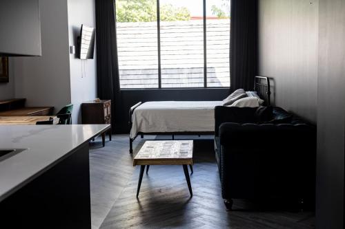 ein Wohnzimmer mit einem Bett, einem Sofa und einem Tisch in der Unterkunft Le Black & White - Vieux-Terrebonne in Terrebonne
