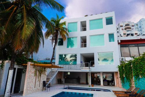 un edificio con piscina y palmeras en Hotel Caribbean Cartagena en Cartagena de Indias