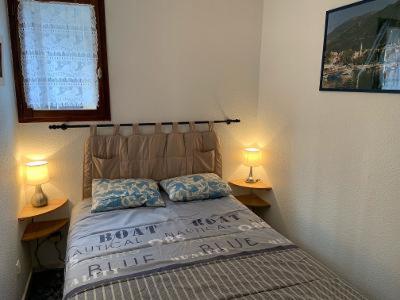 een slaapkamer met een bed met twee lampen op twee tafels bij Chalet Pastel in Morillon