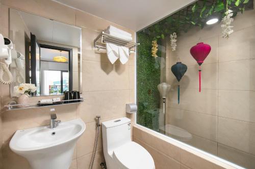 a bathroom with a toilet and a sink and a mirror at Hanoi La Cascada House & Travel in Hanoi