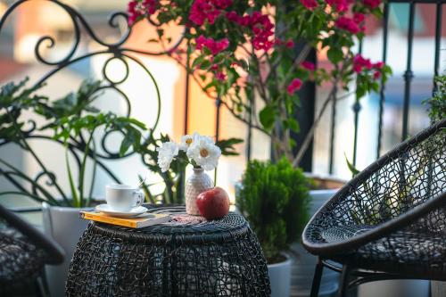 a table with a cup of coffee and an apple on it at Hanoi La Cascada House & Travel in Hanoi