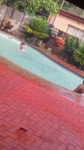 a man is swimming in a swimming pool at Pythons Guest Lodge in Rustenburg