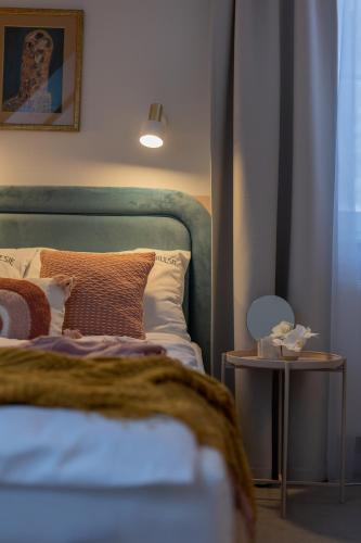 a bedroom with a bed and a side table at Willa Zalesie in Krynica Zdrój