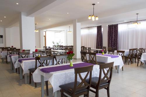 un restaurante con mesas y sillas con manteles morados y blancos en Motel Corsar, en Tulcea