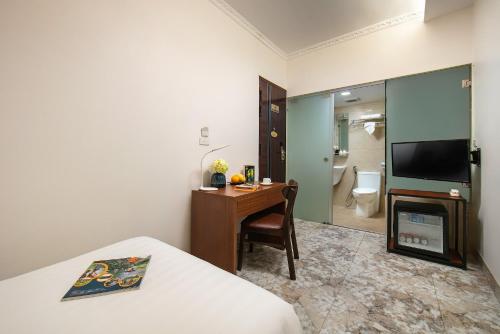 a hotel room with a bed and a desk and a television at Hanoi La Cascada House & Travel in Hanoi