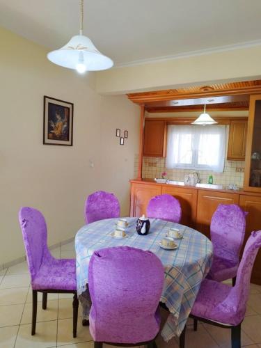 uma sala de jantar com cadeiras roxas e uma mesa em Zoi Country Home by Eutopia em Ioannina