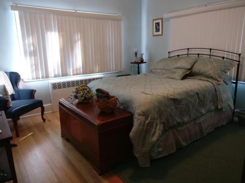 a bedroom with a bed and a chair and a table at Maurrocks - A Pocono Mountains B&B in Mount Pocono