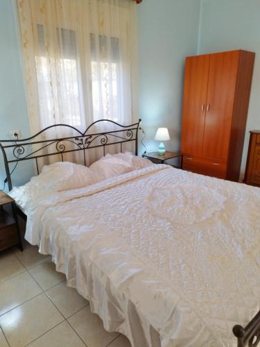 1 dormitorio con 1 cama grande y edredón blanco en Zoi Country Home by Eutopia en Ioánina