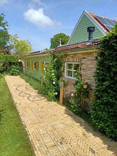 a brick path leading to a house with a green at De Ketse Steenuil in Kaatsheuvel