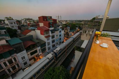 a train is traveling through a city with buildings at Hanoi La Cascada House & Travel in Hanoi