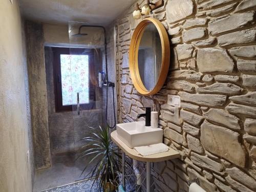 Baño de piedra con lavabo y espejo en Casa Rural Area con piscina, en Gondomar