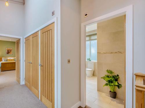 a hallway with a door leading to a bathroom at Clarion Lodge Cottage Ilkley in Menston