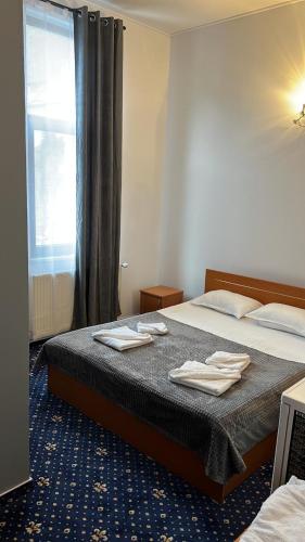 un dormitorio con una cama con toallas encima en Vila Themis, en Călimăneşti