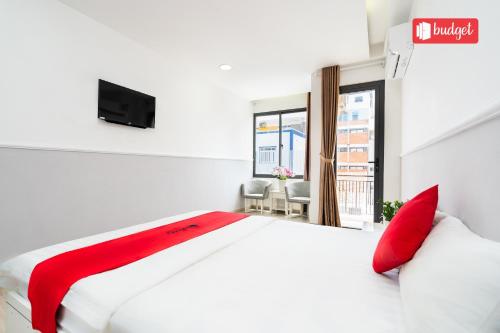 a bedroom with a white bed with red pillows and a window at Khanh Linh Hotel in Vung Tau