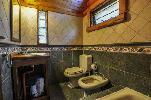 baño con aseo y lavabo y ventana en Cabañas Huincul en Villa Gesell