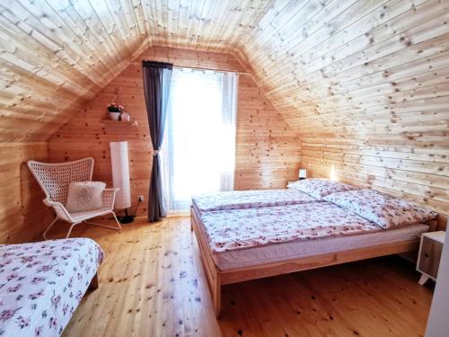 a bedroom with two beds in a log cabin at Czarne Domki Chłopy in Chłopy