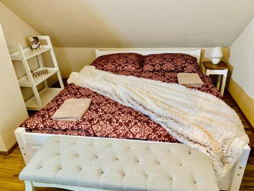 a bedroom with a bed with a comforter on it at Romantické chalúpky Raj-Borievka, Čučoriedka a Drienka in Hrabušice