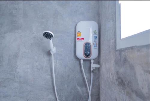 a soap dispenser on the side of a wall at Huen Raya - เฮือนรายา in Amphoe Mae Taeng