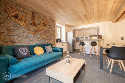泰爾米尼翁的住宿－"Le Temps Suspendu"，客厅设有蓝色的沙发和砖墙