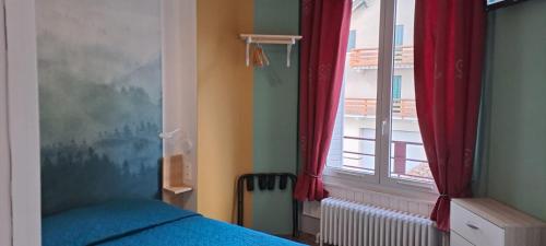- une chambre avec un lit et une fenêtre avec des rideaux rouges dans l'établissement Les 4 Montagnes, à Villard-de-Lans