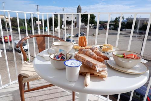 un tavolo bianco con cibo in cima a un balcone di PALAZZO CAMERLENGO Suites Relax a Fasano