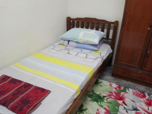a small bed with two pillows on top of it at Idaman guesthouse Malay only in Kubang Semang