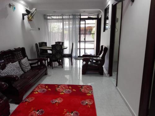 salon z kanapą i czerwonym dywanem w obiekcie Idaman guesthouse Malay only w mieście Kubang Semang