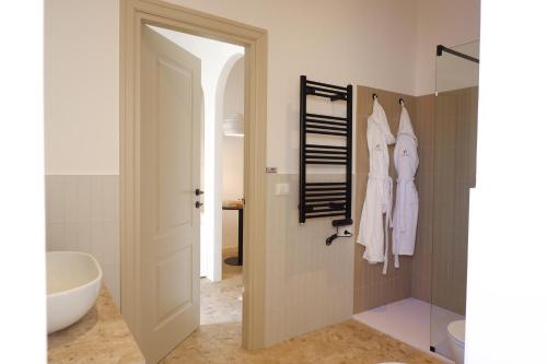 un bagno con lavandino, servizi igienici e porta di PALAZZO CAMERLENGO Suites Relax a Fasano