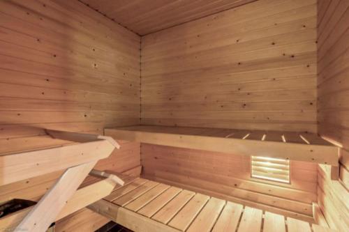 a wooden sauna with a bench in it at Cozy Aparment with sauna nearby Airport in Vantaa