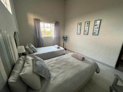 a bedroom with two beds and a couch and a window at Le Soleil in Graskop
