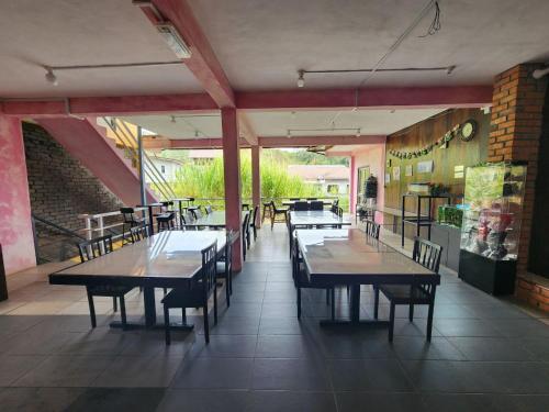a restaurant with tables and chairs in a room at Kupi-Kupi & Stay in Kundasang