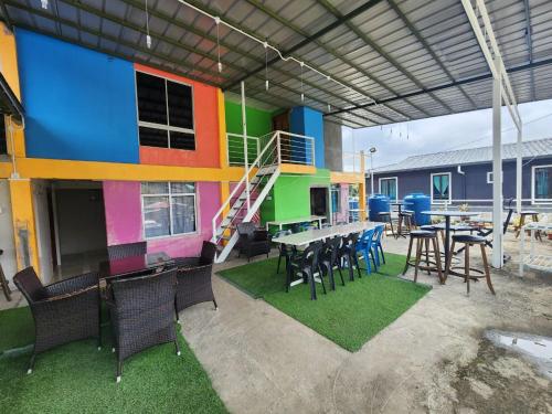 a patio with tables and chairs and a colorful building at Kupi-Kupi & Stay in Kundasang
