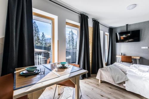 sypialnia ze stołem, łóżkiem i oknem w obiekcie Apartament Sova w mieście Kościelisko